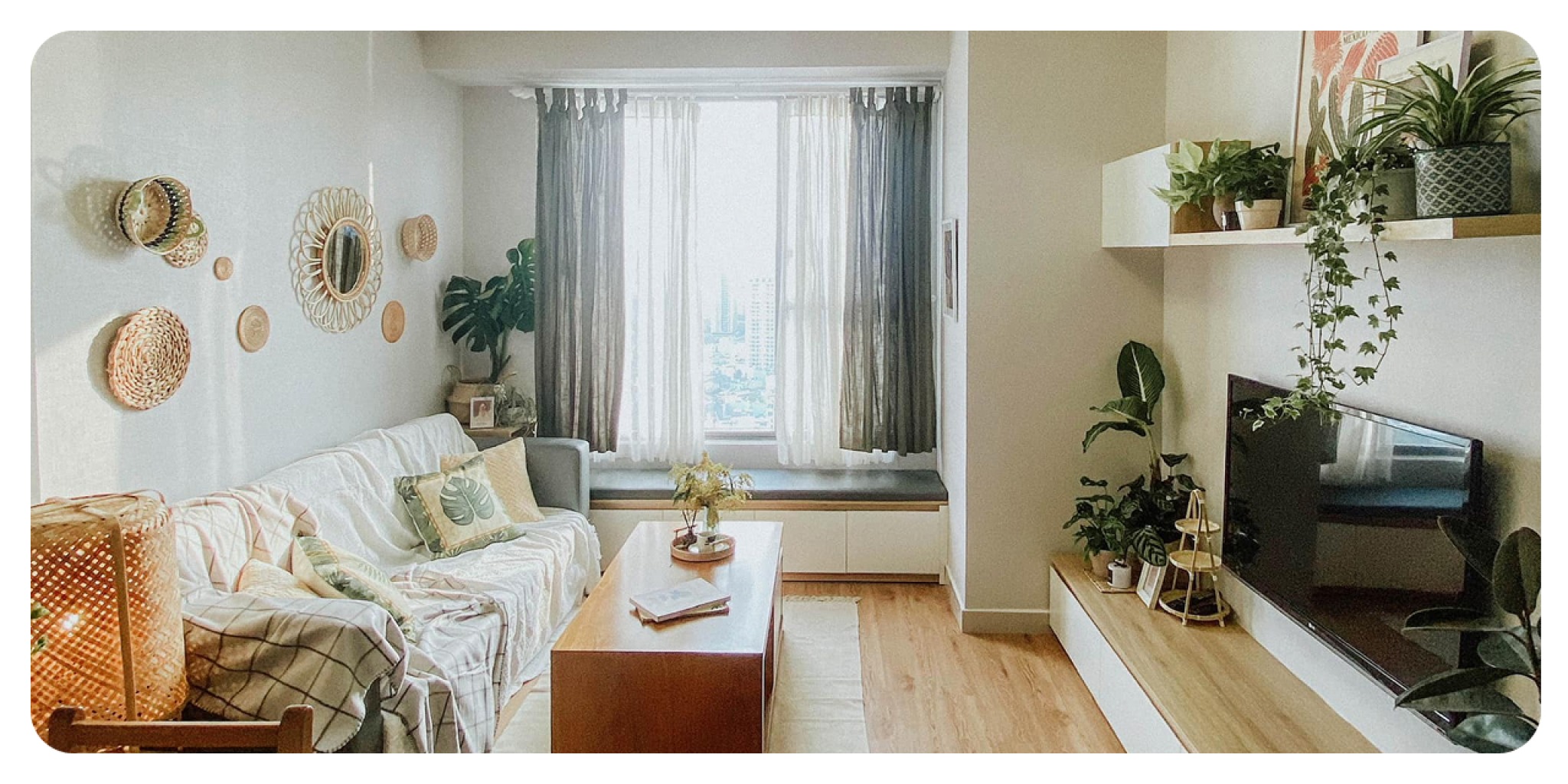 Phòng khách căn hộ Dfour Home được decor với sofa, cây xanh, kệ tivi và ánh sáng dịu, tạo cảm giác ấm cúng và gần gũi như không gian nhà ở cho khách lưu trú.