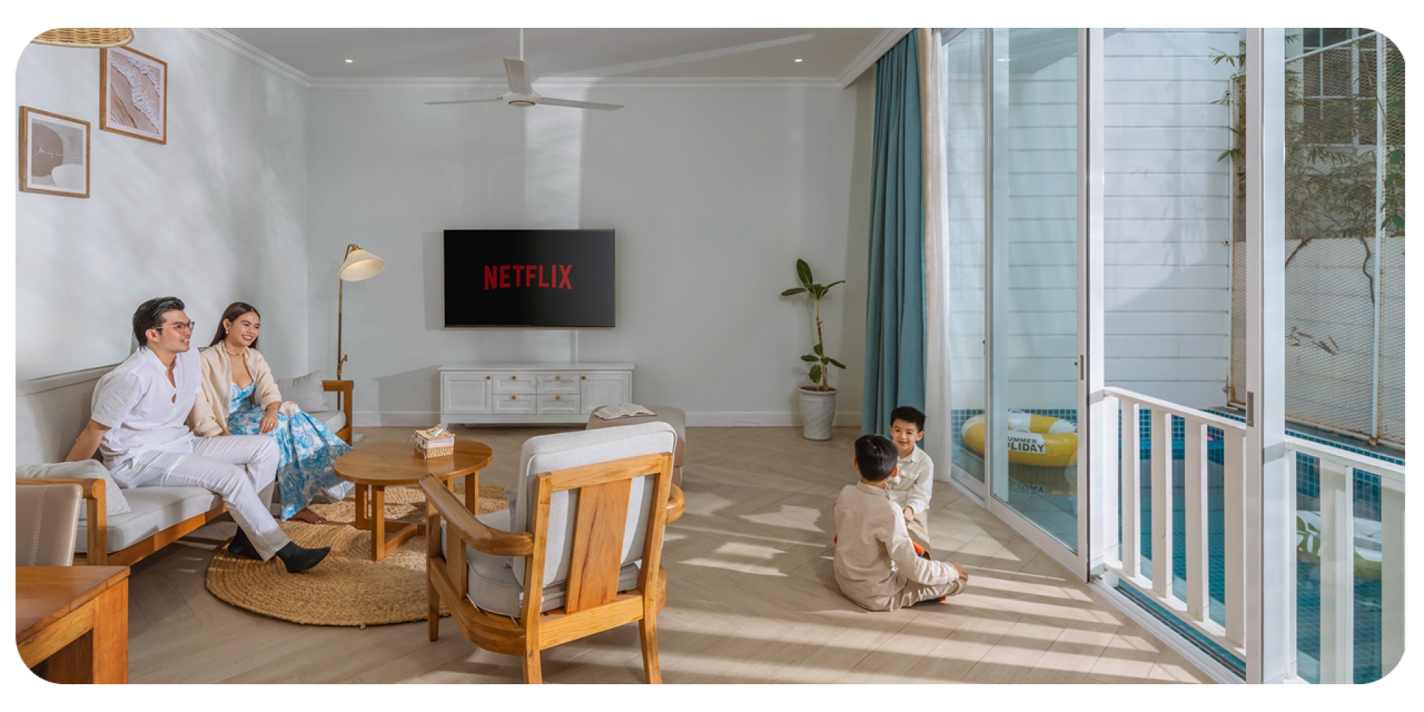 The Salt Collections – Villa cho kỳ nghỉ ấm áp bên gia đình và nhóm bạn. Gia đình và hai bé nhỏ quây quần trong phòng villa tràn ánh nắng, nhìn ra hồ bơi riêng tại villa của The Salt Collections – gợi tả kỳ nghỉ ấm cúng, riêng tư cho gia đình và nhóm bạn